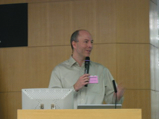 《圖三　SourceForge.net總監Patrick McGovern在會議中開心地和與會者分享SourceForge的成功案例》