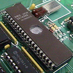 《图一 OTP型微控器即是将原有透光窗式的EPROM型微控器，改以非透光的传统封装而成，由于刚出厂的芯片内是全新未用的EPROM，因此仍可进行一次程序刻录，之后无法将数据清除，图为传统使用透光窗封装的微控器：8749（2KB EPROM型的8048微控器）。》