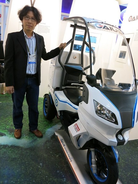 图1 : 盖亚汽车设计总监谢孟峰表示盖亚的电动机车可载货，底座是无线充电板。