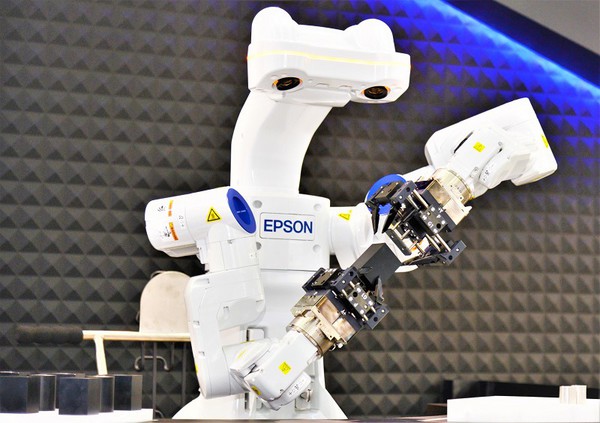 圖4 : Epson雙臂機器人具備AI、2D/3D視覺及智能校正、力覺與多工/快換夾爪功能，未來能不必編程、教點、排列原材料，即可自主完成辨識、組裝等作業，大幅減省人力及成本。（攝影／陳念舜）